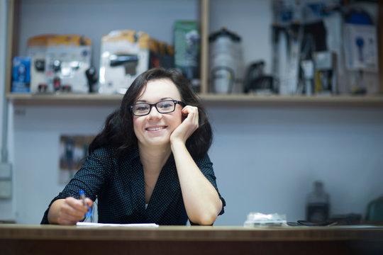 Portrait of woman at counter looking at camera smiling