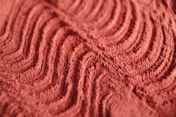 Red moroccan cosmetic clay powder texture close up, selective focus. Abstract background. 