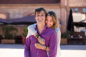 Portrait of smiling young and beautiful couple in the street