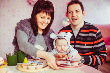 The happinest family sits near table with cakes