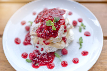 waffles with raspberries on wooden table, selective focus, lights effects.