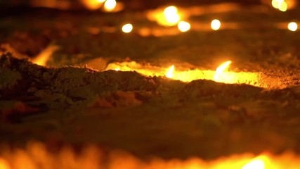 Asian candles in sand in religious ceremony , windy. Slide. Slow motion
