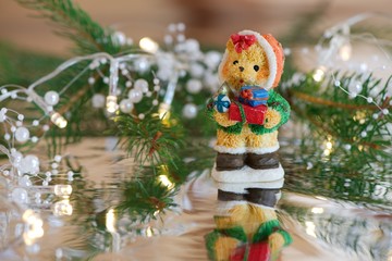 Christmas decoration: bear with presents, pearl lights and a branch of Christmas tree with reflection