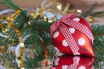 Red Christmas heart with golden serpentine and a Christmas tree branch