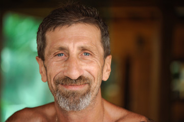 Obraz premium Portrait of smiling mature man at blurred background