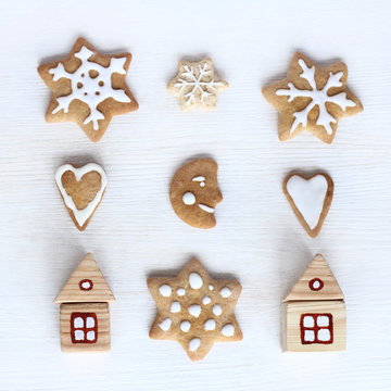 meet the new year with appetite/ flat layout of wooden houses and curly festive cookies top view 