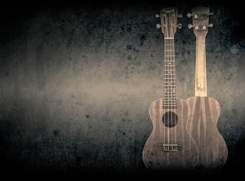 Part of a orange acoustic guitar on black background. © YB