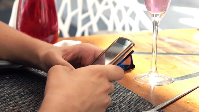 Teenage boy using smartphone sitting in cafe
