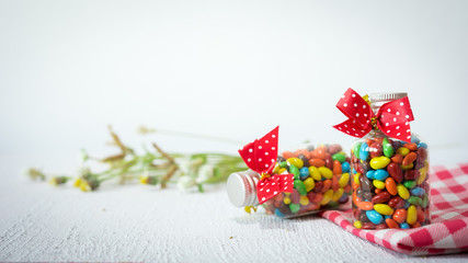 Fototapeta na wymiar Baby Gift Colorful candies in jar on table