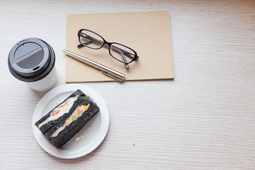 A coffee cup with charcoal sanwiches