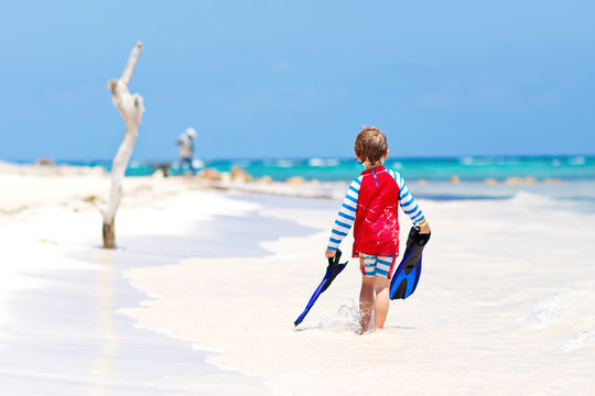 little blond kid boy having fun on tropical beach of Maldives