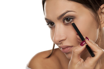 young woman applied eyeliner.