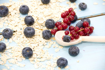 Fresh berries raspberry, red currant, blueberry in glass bowl on wooden table