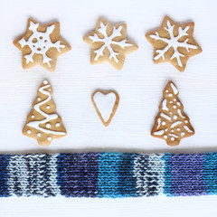 atmosphere is a favorite winter vacation/ flat layout of curly festive cookies and warm blue scarf top view 