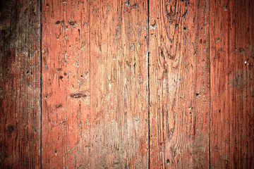 Old wooden planks painted with dark pink paint cracked by a rust