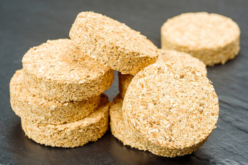 Stacks of hardwood smoker bisquettes made of wood chips.
