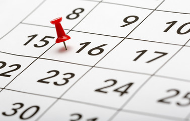 Pin on the date number 16. The sixteenth day of the month is marked with a red thumbtack. Focus...