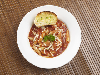 PENNE ARRABIATA SERVED IN A WHITE PLATE ON WHITE BACKGROUND