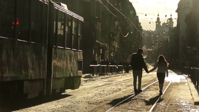 Beautiful happy stylish couple walking and holding hands on streets of european city in winter morning. Lviv city, Ukraine
