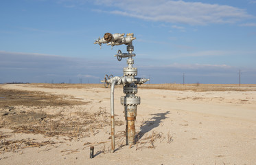 Natural gas wellheads in a plowed cornfield. - 127399532