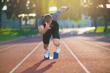 Sprinter leaving starting blocks on the running track. Explosive start.
