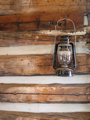 Antique Lantern Hanging on a Log Cabin Wall - obrazy, fototapety, plakaty