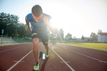 Obraz premium Sprinter leaving starting blocks on the running track. Explosive start.