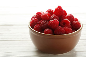 Fototapeta na wymiar Fresh raspberries in bowl on table