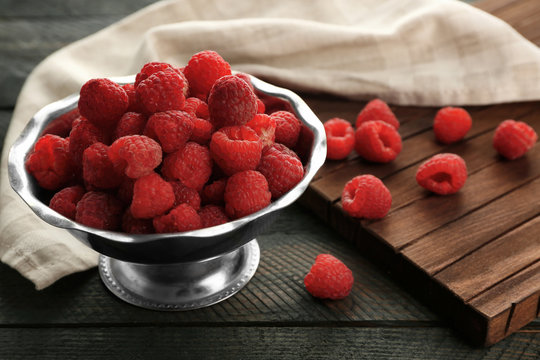 Fresh raspberries in bowl on table, closeup
