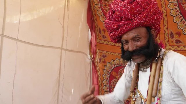 Funny man from Rajasthan with big moustache dancing with a kid