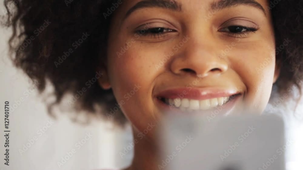 Wall mural happy african woman with smartphone