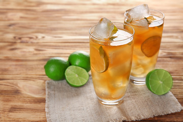 Glasses of iced tea with lime slices and mint on napkin