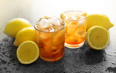 Glasses of iced tea with lemon slices on gray background