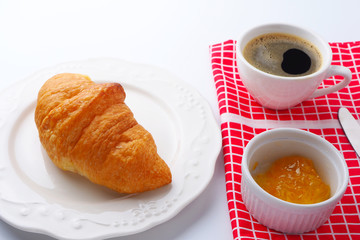 Top view of breakfast with croissants and a cup of black coffee.