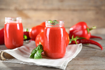 Glass jars with vegetable smoothie on wooden table