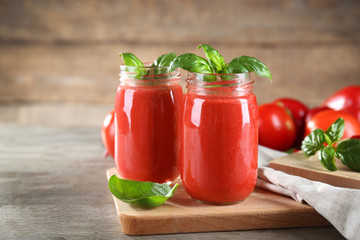 Glass jars with vegetable smoothie on wooden table