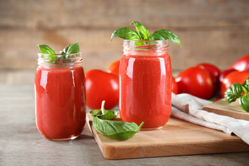 Glass jars with vegetable smoothie on wooden table