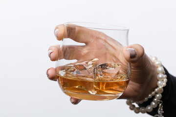 Frauenhand hält ein Glas mit Whiskey