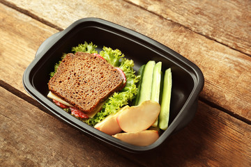 Lunch box with food on wooden background