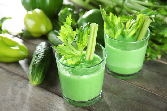 Glasses of fresh vegetable smoothie on wooden table