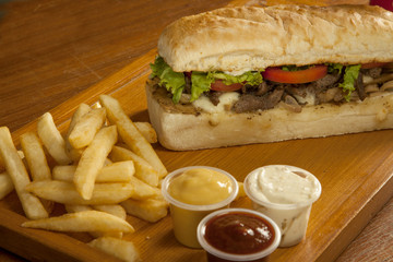 Submarine sandwich with french fries and dip sauces