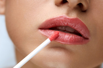 Beauty Makeup. Beautiful Woman Applies Lip Gloss