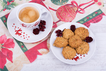 Christmas cup of coffee and cookies on a festive tablecloth