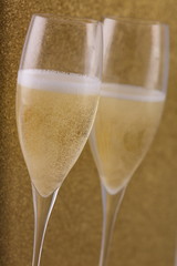 Flute con vino bianco su fondo oro