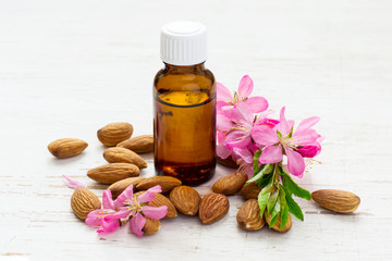 small bottle of almond oil, almonds and flowers