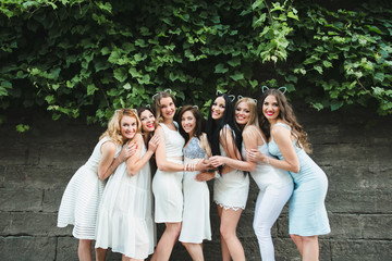 The future bride with girls stand near trees