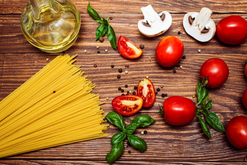 Ingredients for cooking  pasta with vegetables, oil and herbs on wooden rustic background. Top view