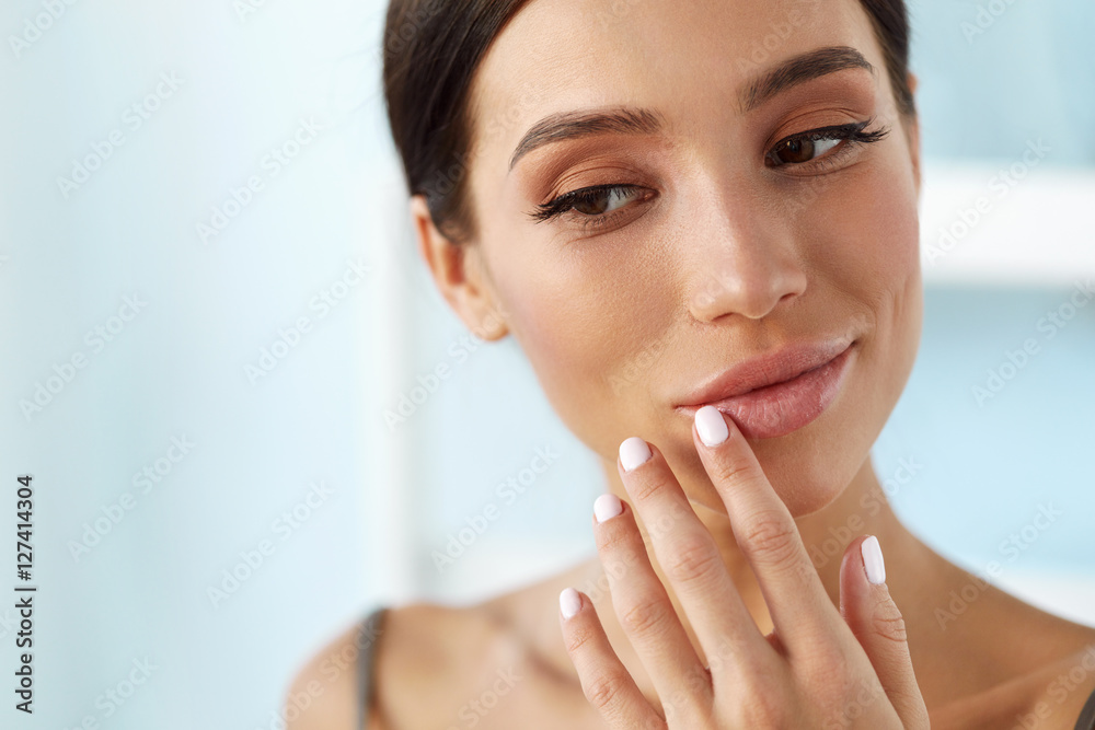 Wall mural lips skin care. woman with beauty face applying lip balm on