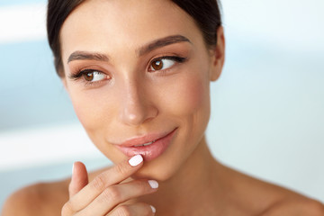 Beauty Face. Beautiful Woman Touching Lips With Lip Balm On © puhhha