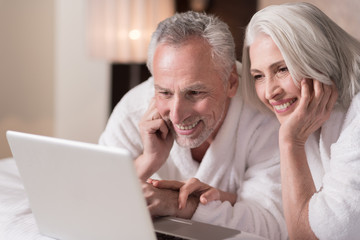 Delighted aged couple watching a movie at home